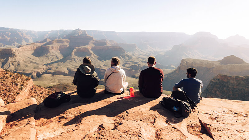 Students sitting together looking over edge of canyon
