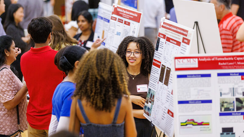 Students discussing project at research fair