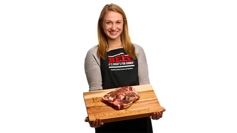 Student holding cutting board with food on it
