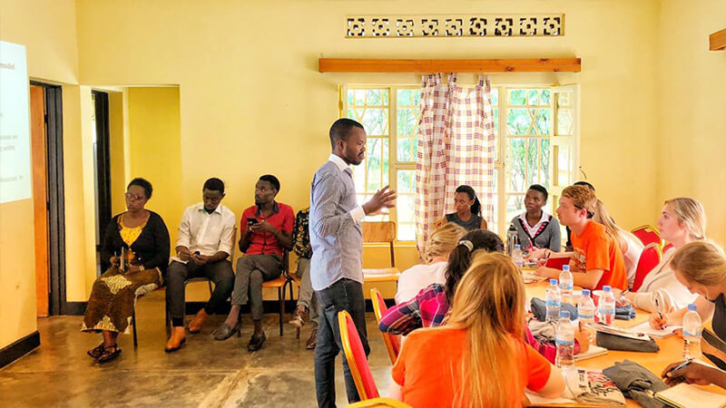 Students at table listen to speaker in Rwanda.