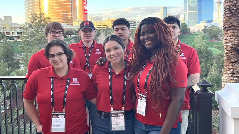 Group of seven student pose for photo wearing red UNL Engineering polo shirts.