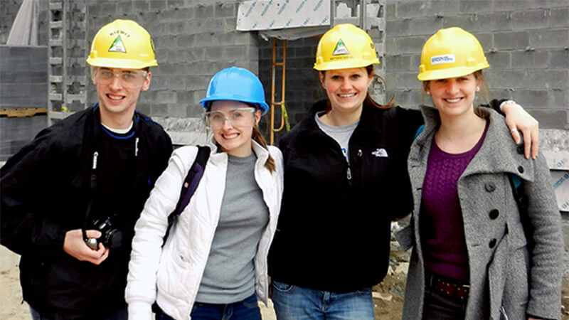 Students wearing hard hats and giving thumbs up