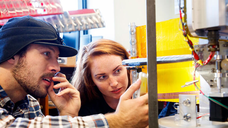 Students work with CNC machine in lab