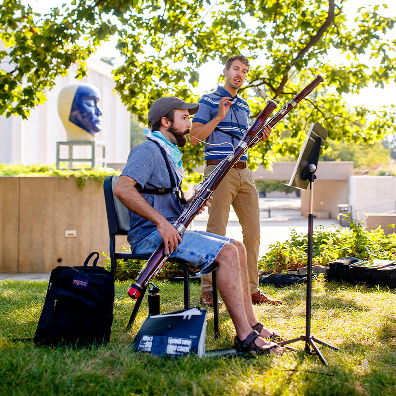 Students practice bassoon outdoors on late summer morning