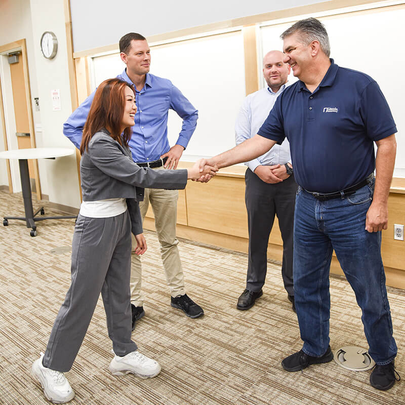 Student shaking hands with faculty member