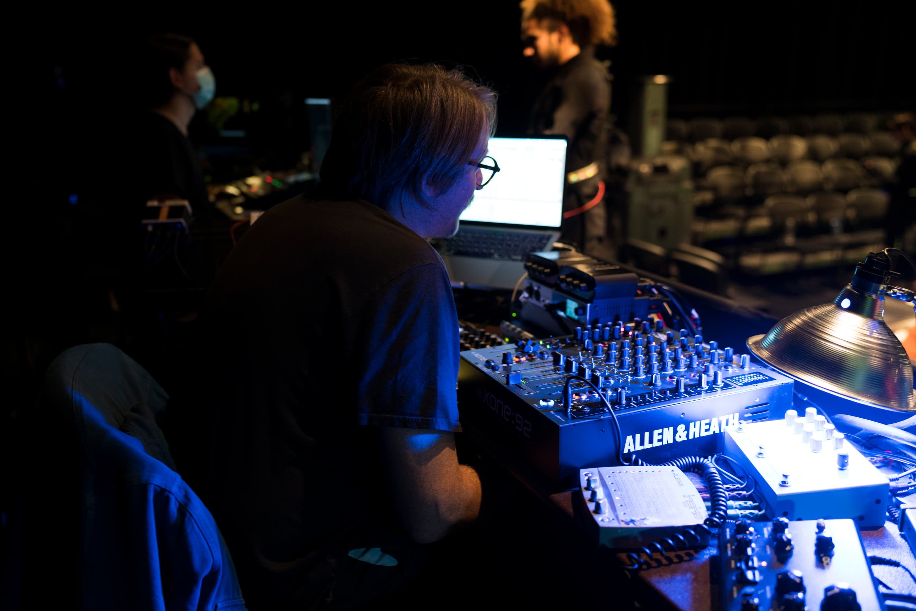 Students working on tech equipment during performance.