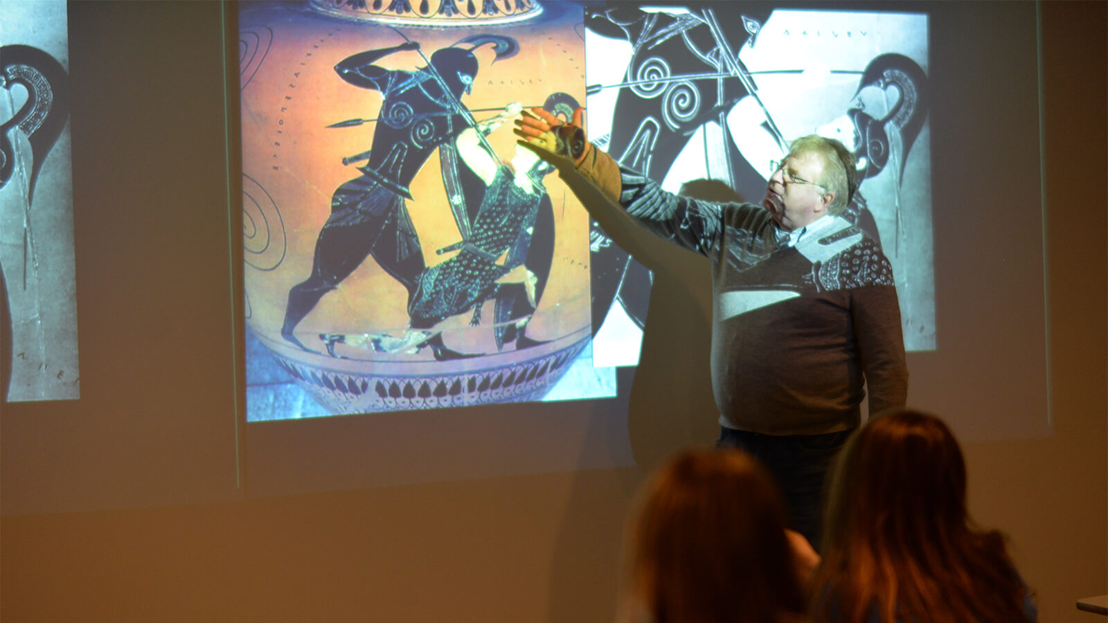 Faculty member pointing to artwork on projection screen