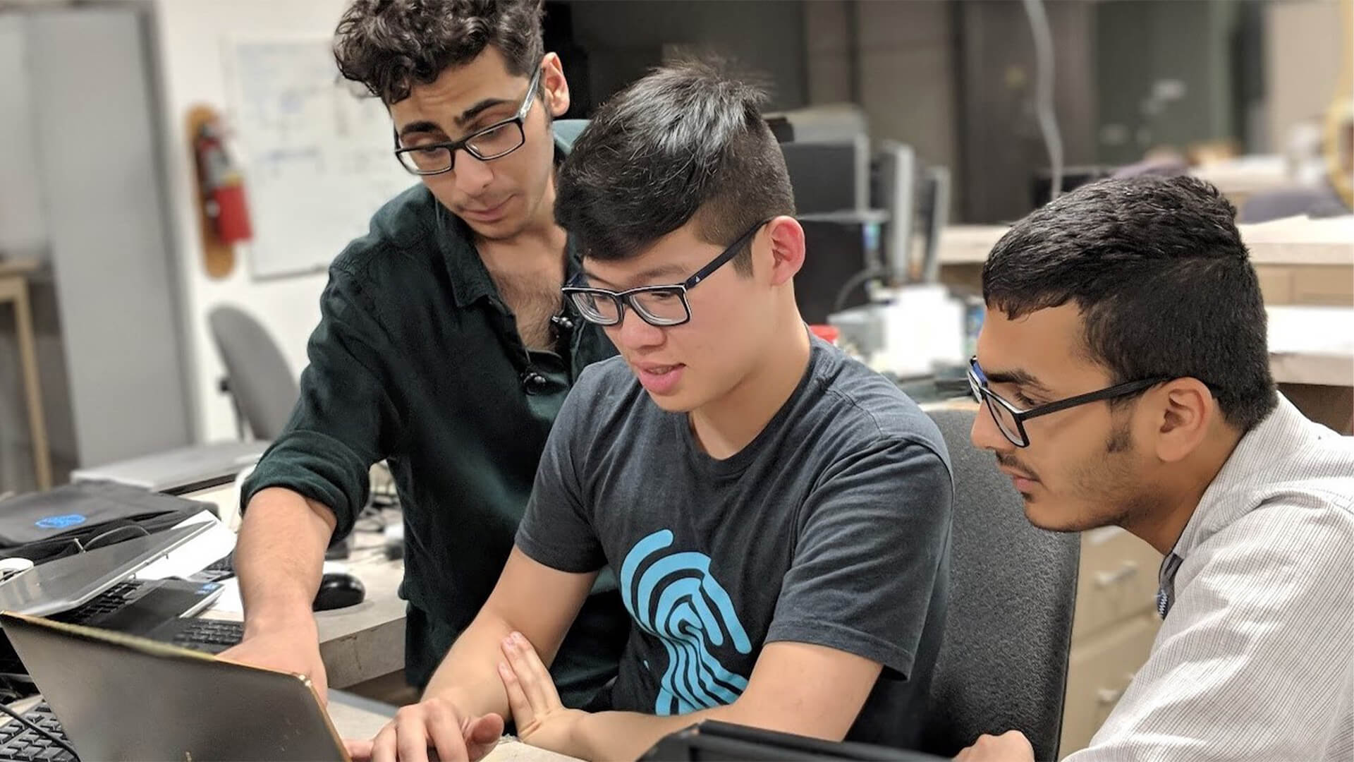 Students looking at work on laptop