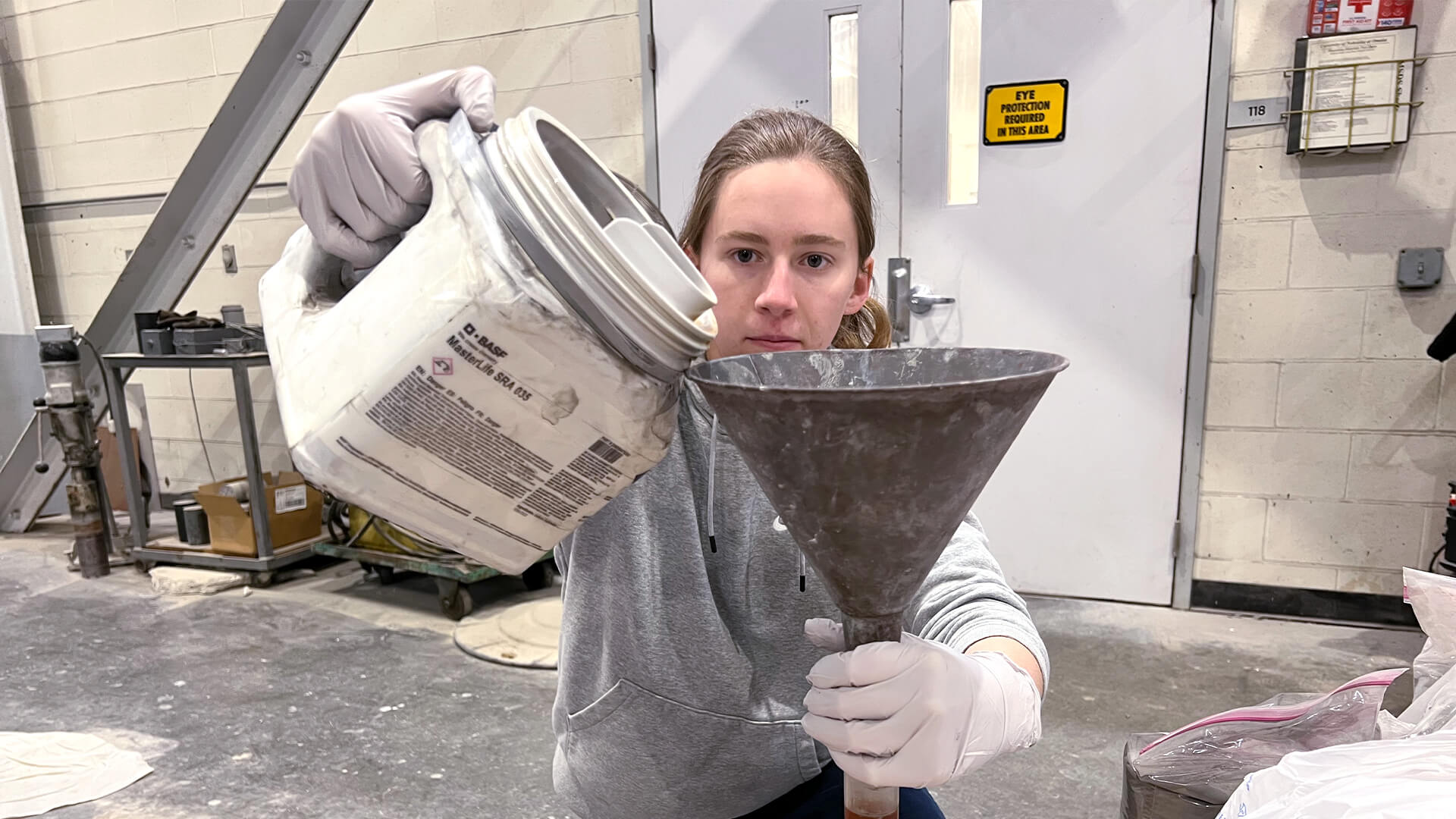 Female student pour material into funnel.