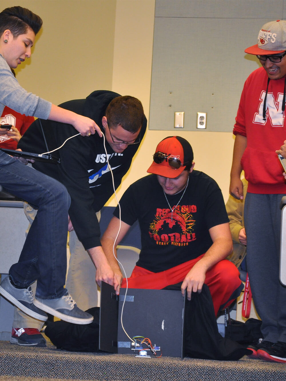 Engineering students work with computer control interfaces.