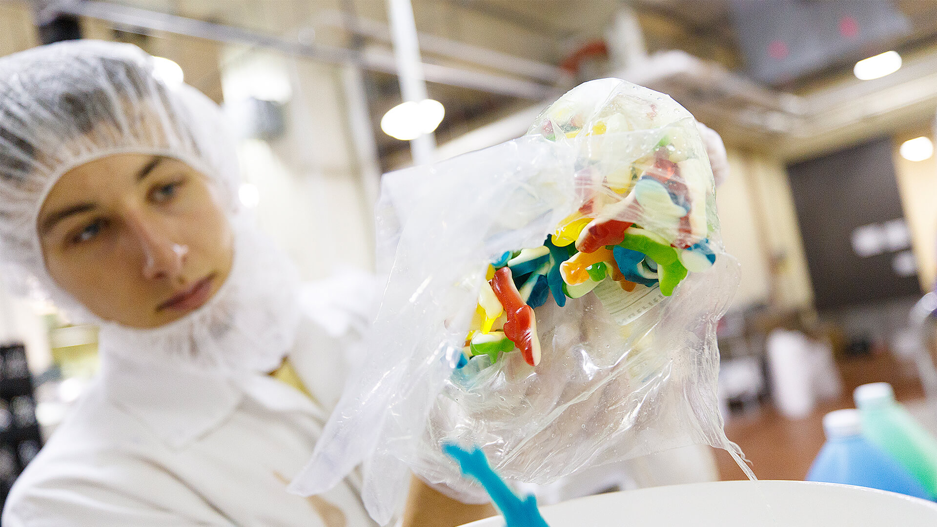 Student researcher dropping colorful gelatin fish into a bucket