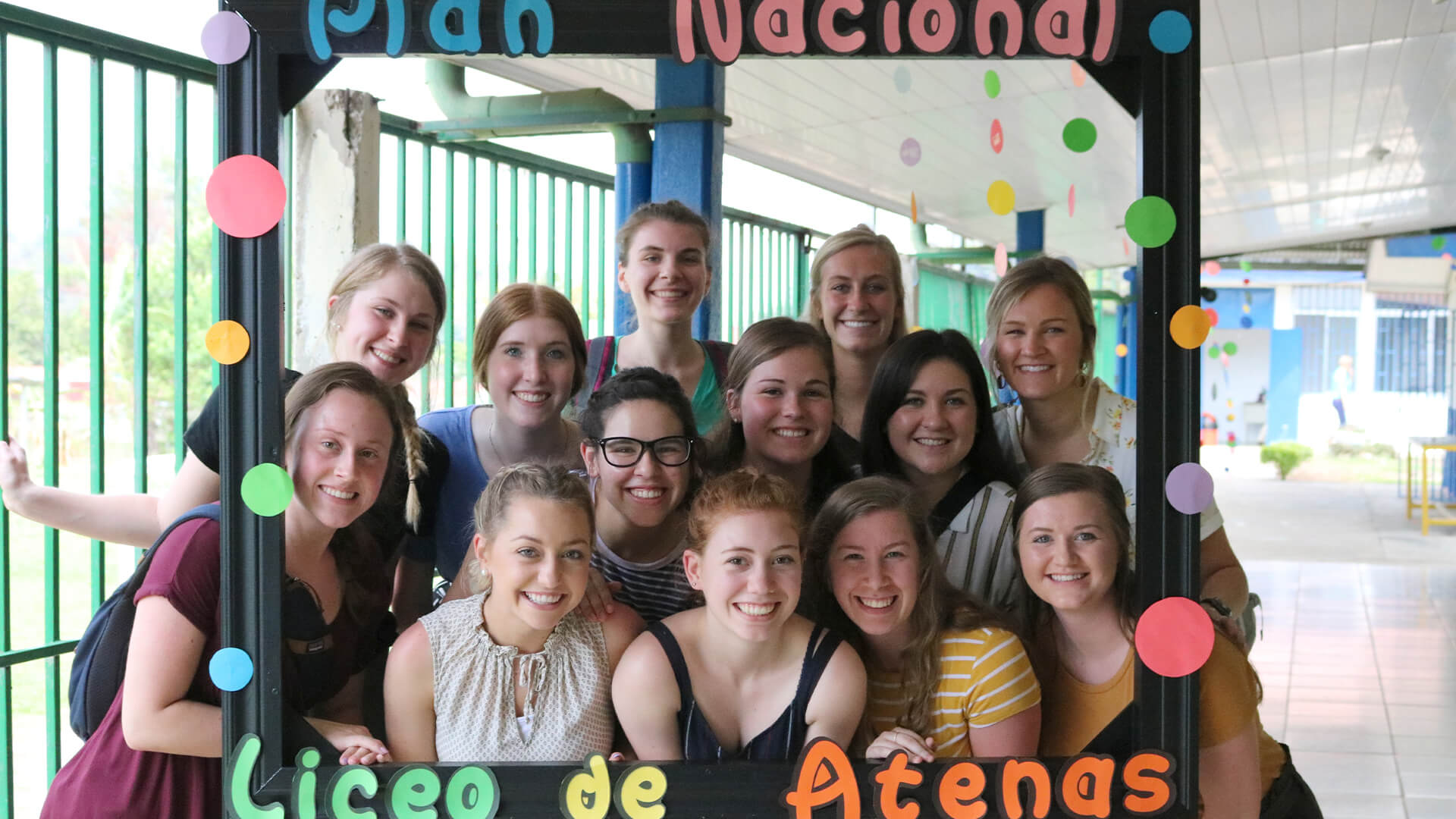 Special ed student teachers pose for a photo in an oversized frame at Liceo de Atenas, Costa Rica.