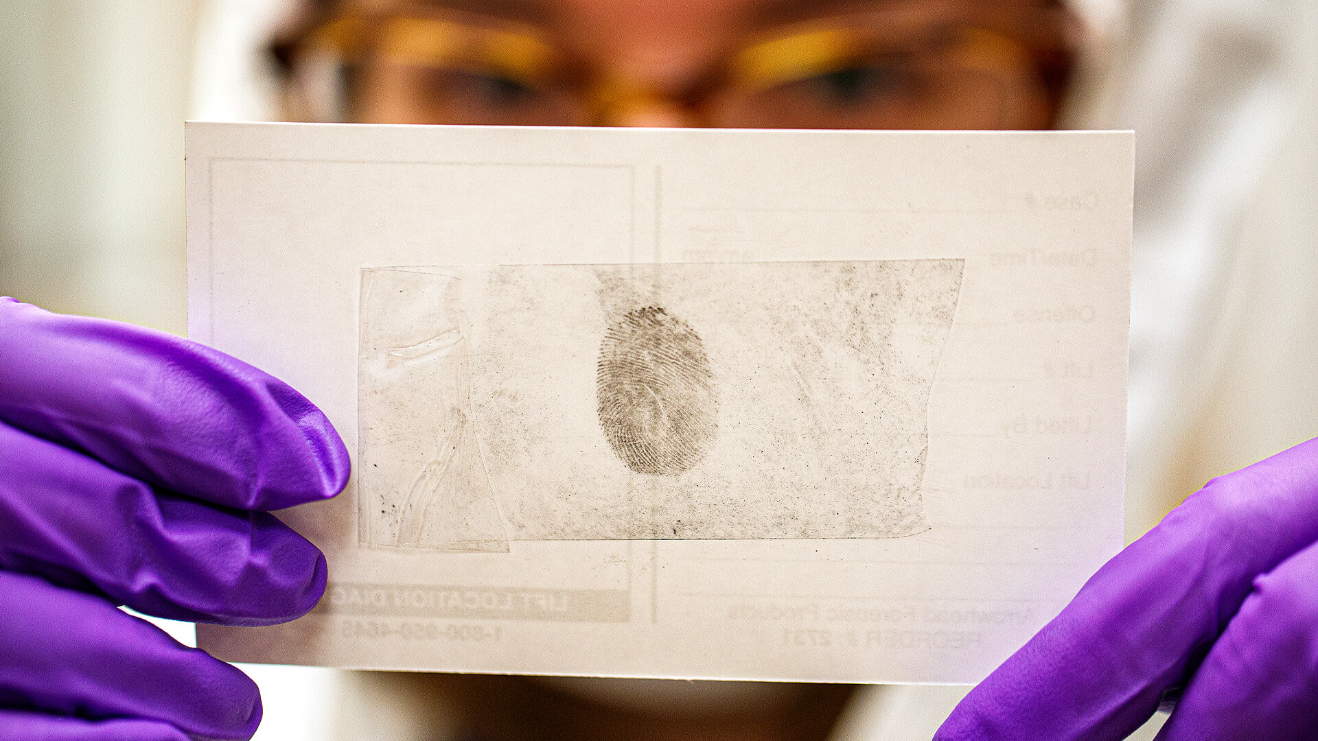 Student researcher examining a lifted fingerprint