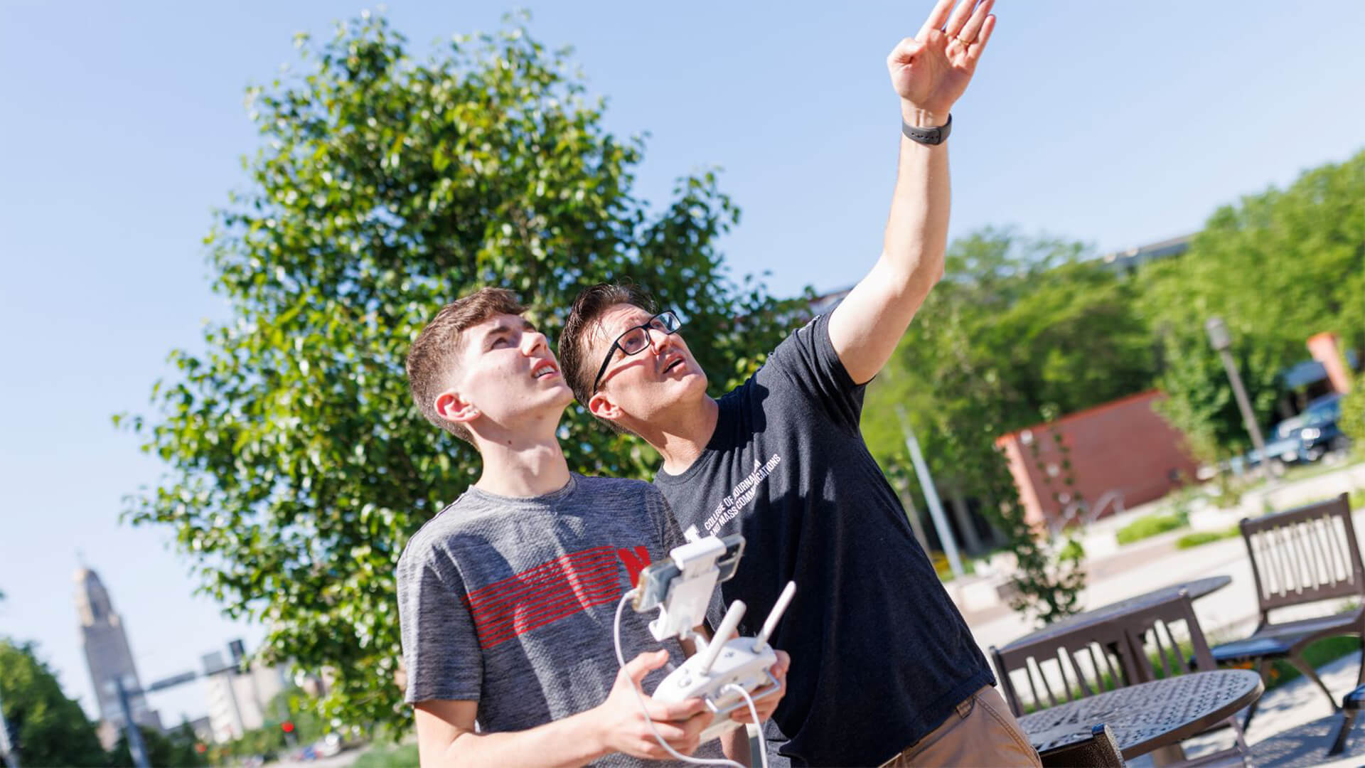 Faculty talking to student while flying drone