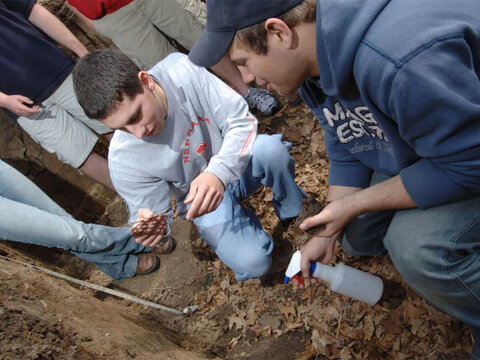 A group of students examine soil