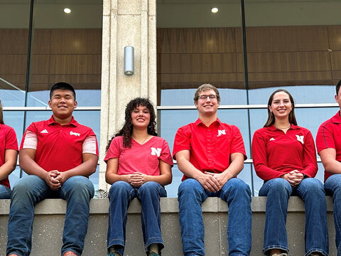 Students in red shirts posing for photo.