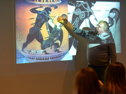 Faculty member pointing to artwork on projection screen